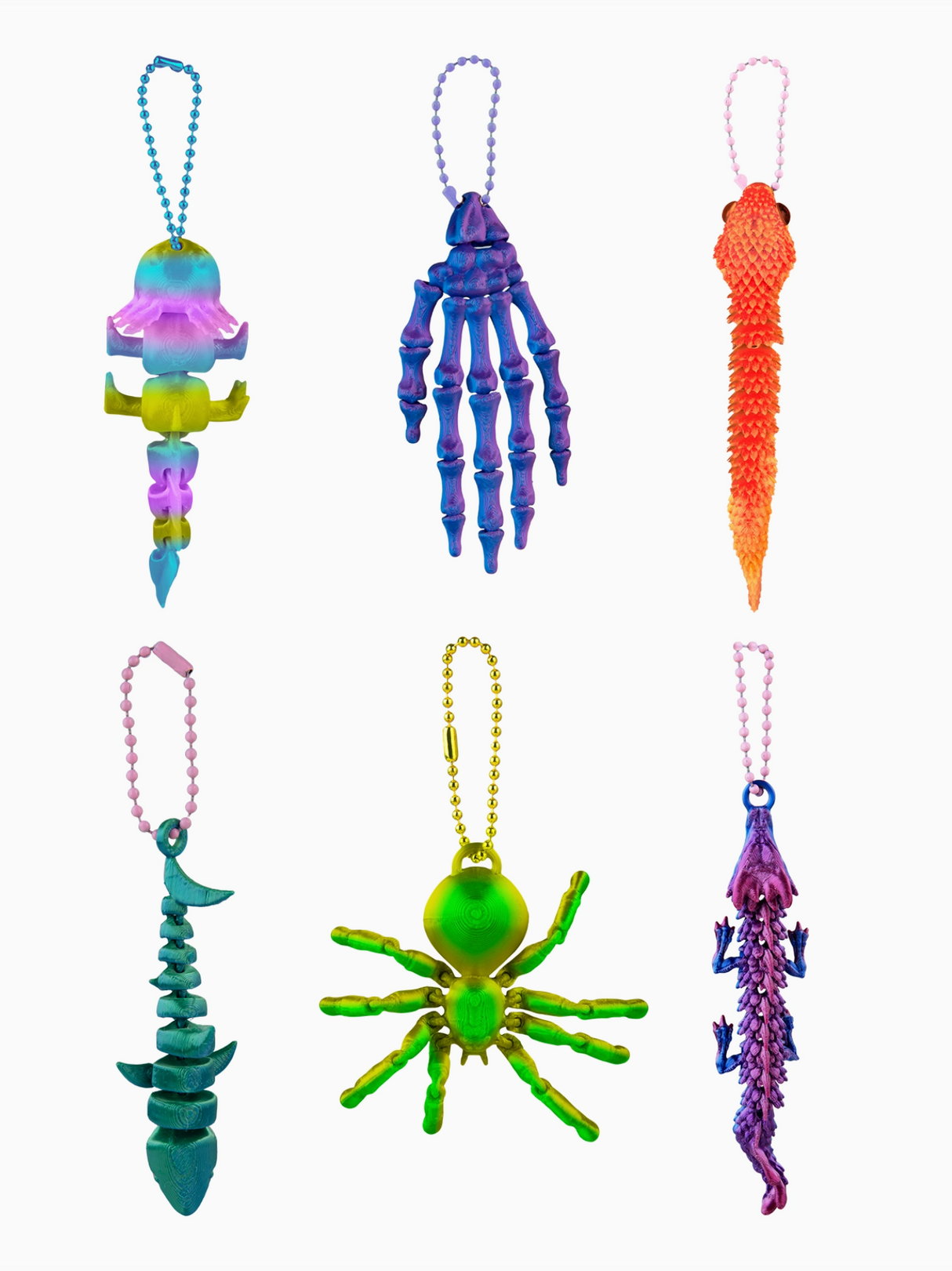 Set of colorful keychains shaped like a skull, cone, spider, and other designs on a white background.